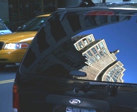 Picture of Midtown NYC buildings reflected on an SUV 